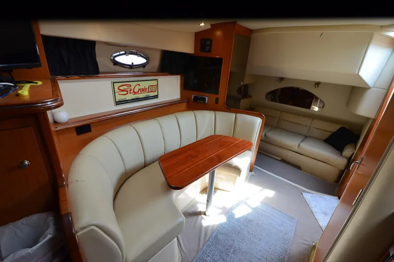 Slide: The Image of 2004 Cruisers Yachts 320 Express interior with beige seating and wooden table. - 22