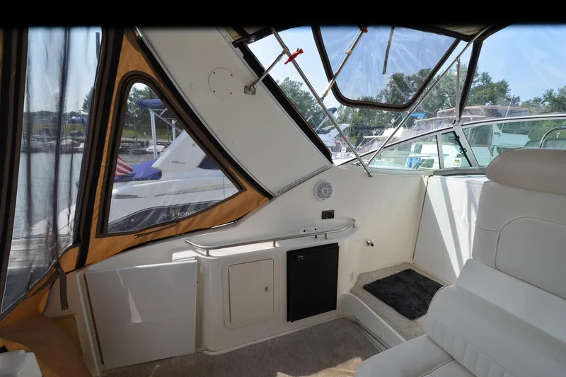 Slide: The Image of 2004 Cruisers Yachts 320 Express interior with seating and window view of marina. - 5