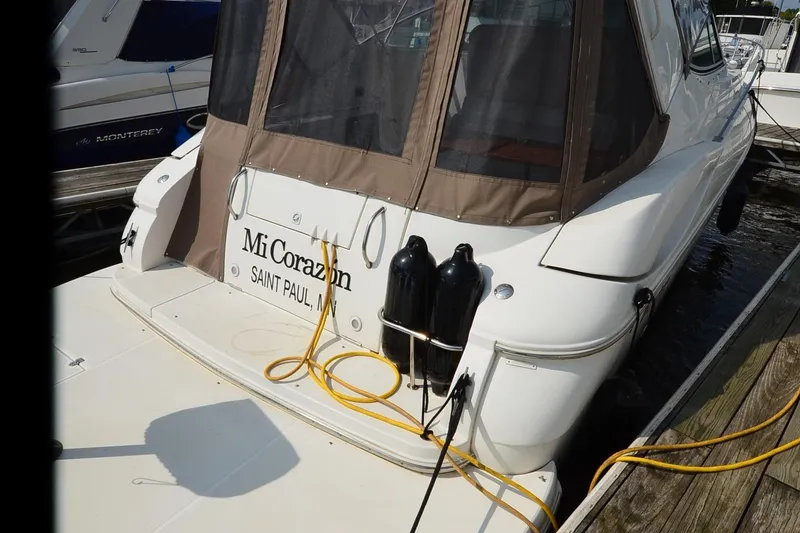 Slide: The Image of 2004 Cruisers Yachts 320 Express docked, rear view with protective cover and mooring lines. - 6