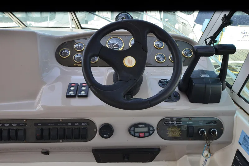 Slide: The Image of 2004 Cruisers Yachts 320 Express helm with steering wheel and control panel. - 9