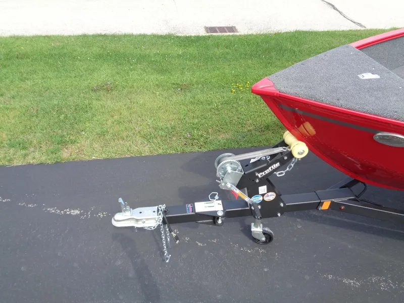 Slide: The Image of 2024 Lund 1650 Angler boat on trailer, parked on asphalt near grass. - 4