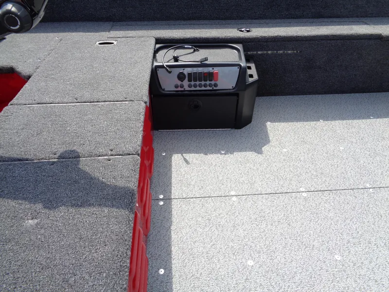 Slide: The Image of 2024 Lund 1650 Angler boat interior with control panel and carpeted flooring. - 8