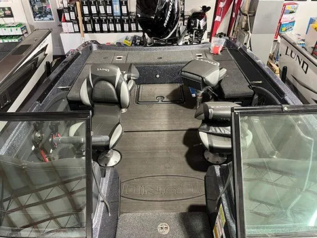 Slide: The Image of 2025 Lund 219 Pro-V GL boat interior with seating and storage compartments. - 13