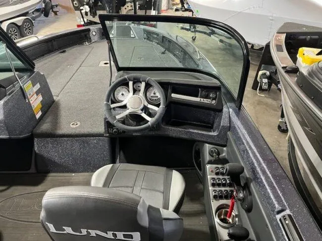 Slide: The Image of 2025 Lund 219 Pro-V GL boat interior with steering wheel and control panel. - 14