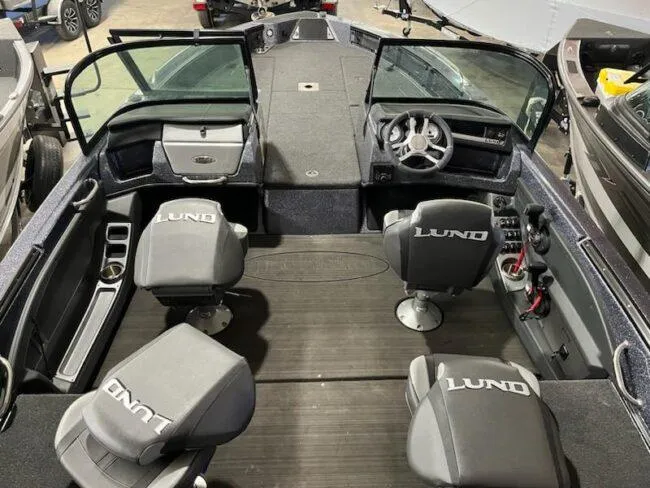 Slide: The Image of 2025 Lund 219 Pro-V GL boat interior with four seats and steering console. - 15