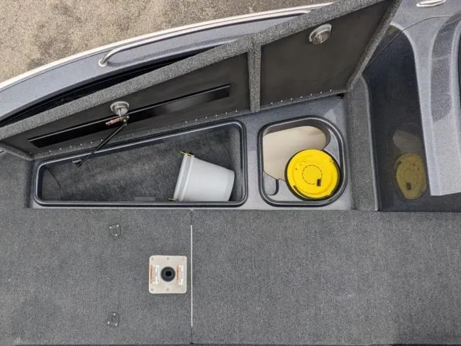 Slide: The Image of 2025 Lund 219 Pro-V GL boat storage compartments with bucket and yellow container. - 4