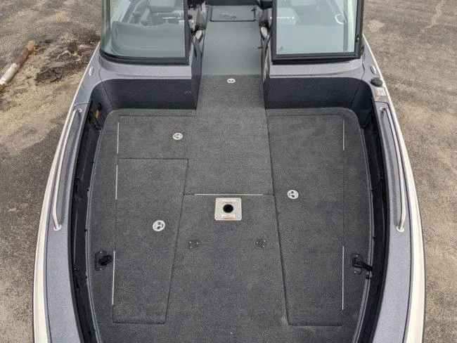 Slide: The Image of 2025 Lund 219 Pro-V GL boat interior, spacious deck with storage compartments. - 9