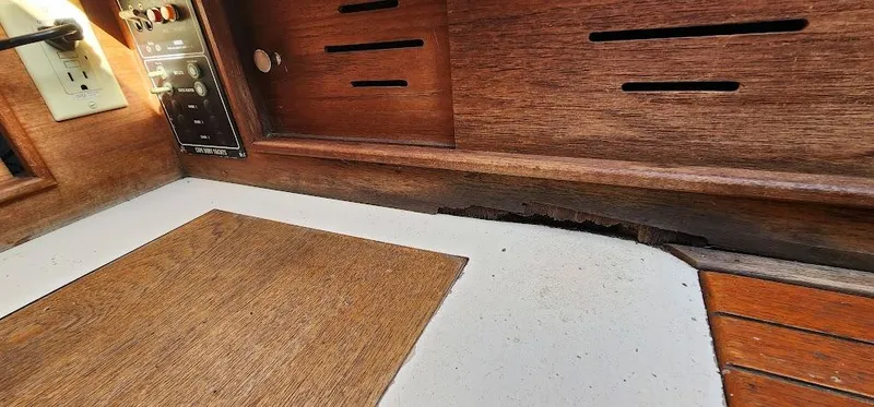 Slide: The Image of Interior view of a 1980 Cape Dory 30 sailboat with wooden paneling and electrical controls. - 17