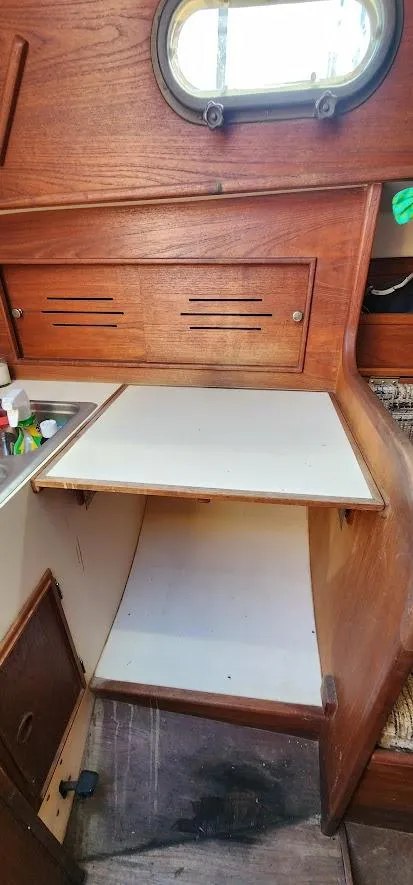 Slide: The Image of 1980 Cape Dory 30 interior with wooden cabinetry and small porthole window. - 20