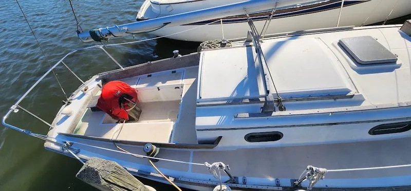 Slide: The Image of 1980 Cape Dory 30 sailboat docked, featuring a spacious deck and classic design. - 27