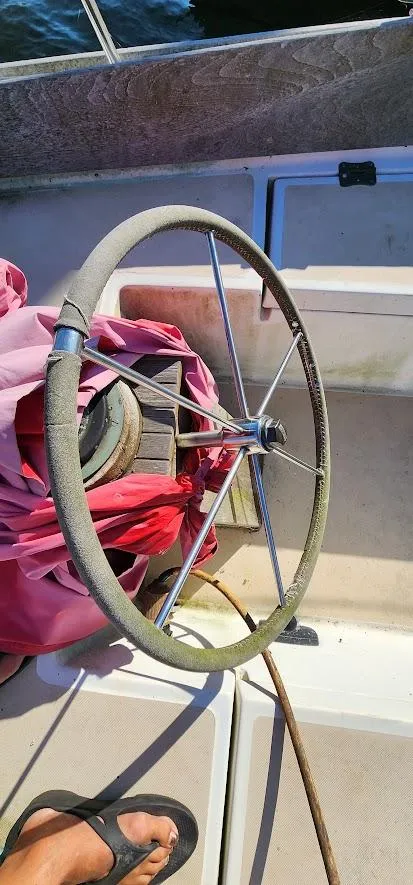 Slide: The Image of Steering wheel of a 1980 Cape Dory 30 sailboat with pink fabric nearby. - 42