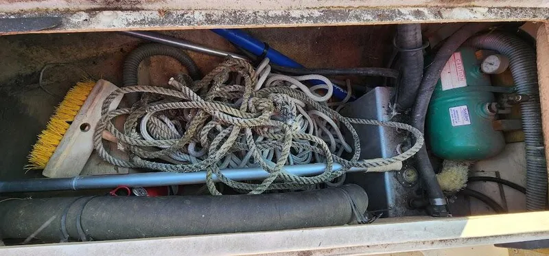 Slide: The Image of Storage compartment of a 1980 Cape Dory 30 sailboat with ropes and cleaning tools. - 43