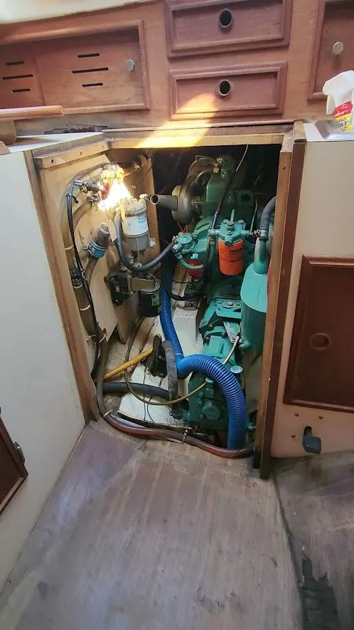 Slide: The Image of Engine compartment of a 1980 Cape Dory 30 sailboat, showing mechanical components and storage. - 48