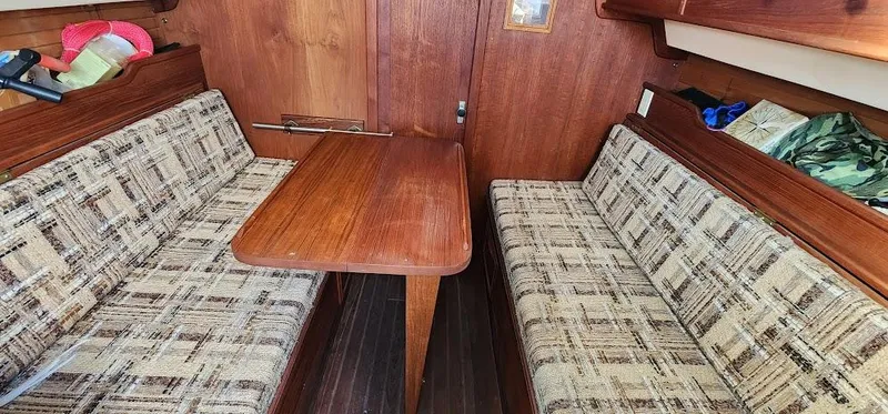 Slide: The Image of Interior of 1980 Cape Dory 30 sailboat with wooden table and patterned seating. - 6