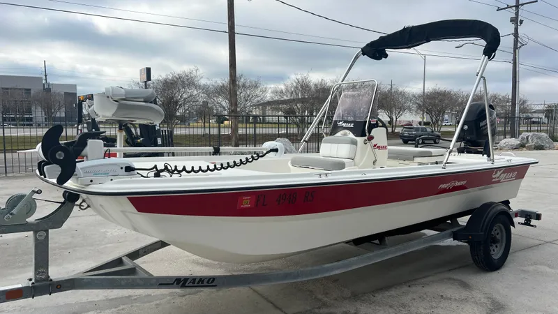 Slide: The Image of 2018 Mako Pro Skiff 17 CC boat on trailer with red stripe and canopy. - 7