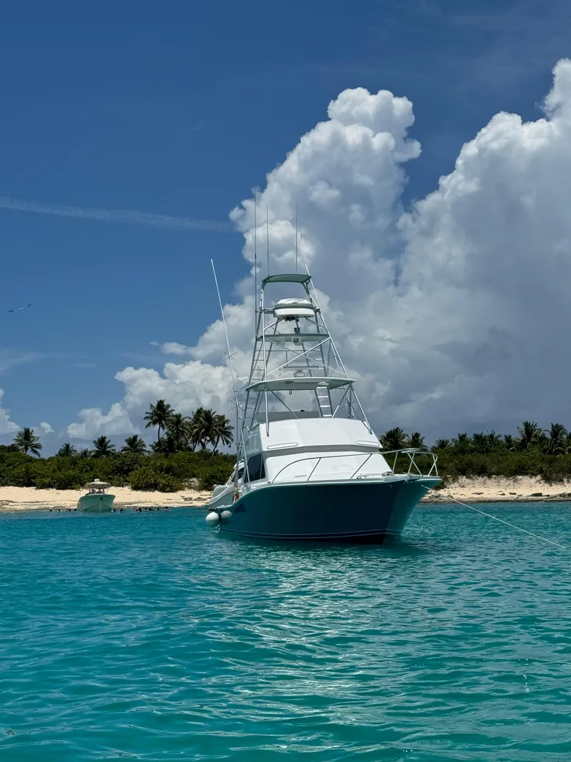 The Image of Viking 43 Convertible yacht anchored in turquoise waters near a tropical beach, 1997 model. - 0
