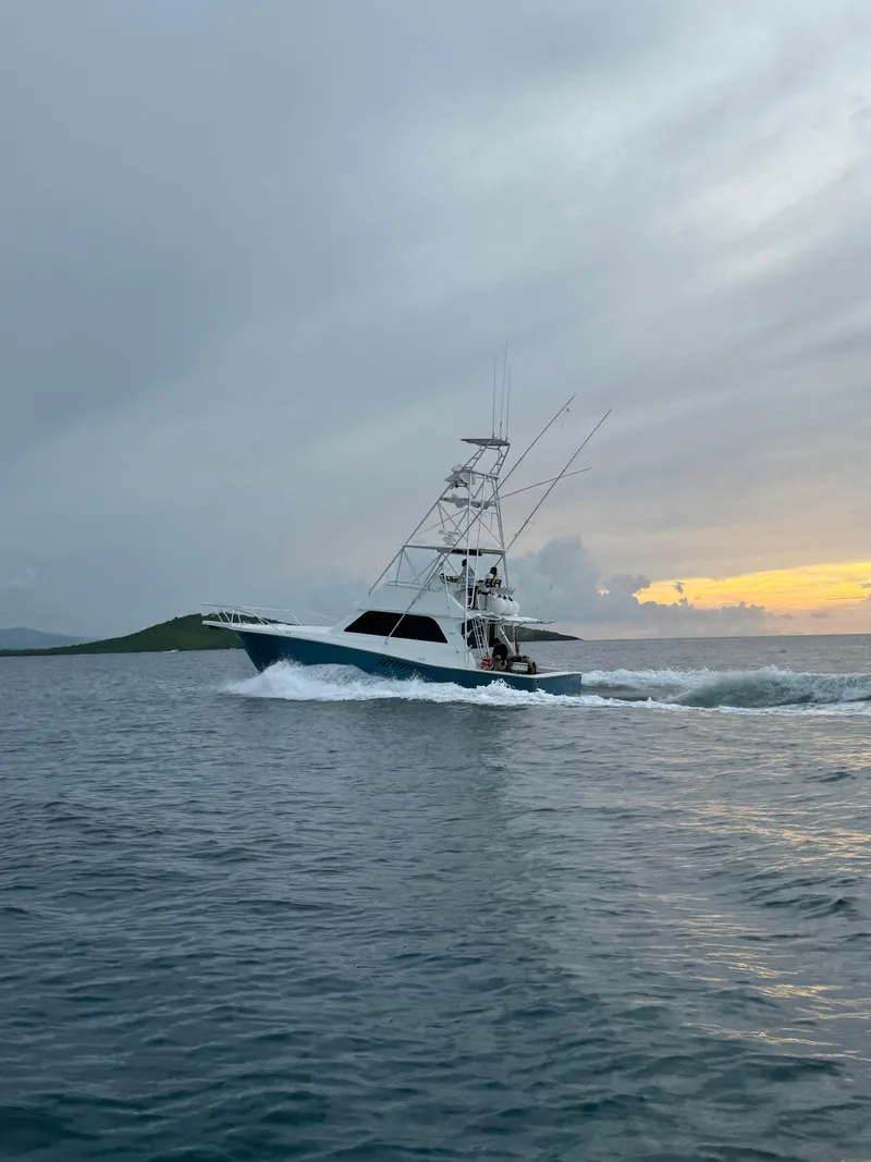 Slide: The Image of 1997 Viking 43 Convertible yacht cruising at sunset on open water. - 12