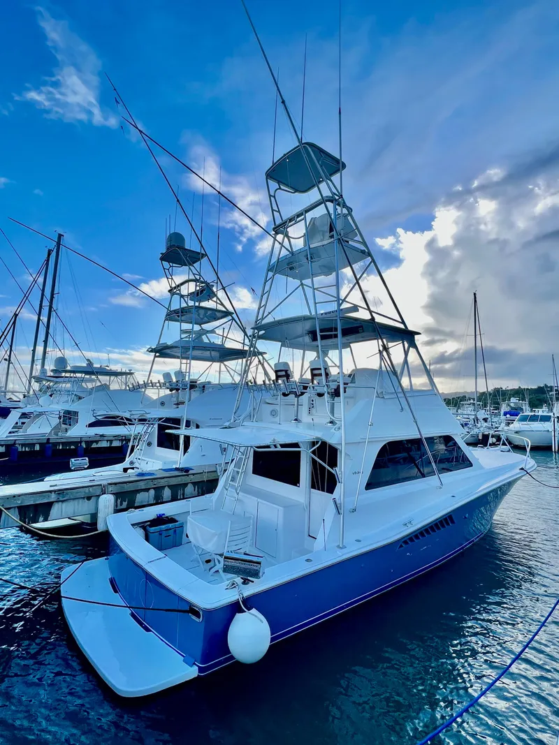 Slide: The Image of 1997 Viking 43 Convertible yacht docked at marina under blue sky. - 16