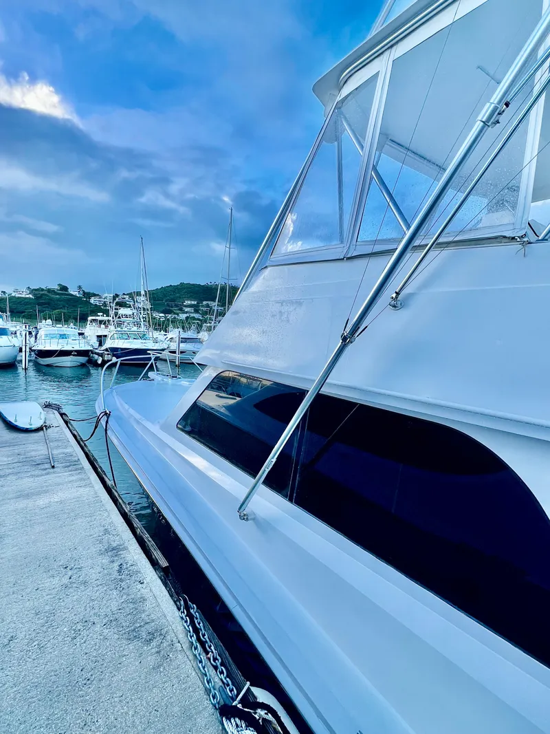 Slide: The Image of 1997 Viking 43 Convertible yacht docked at a marina under a cloudy sky. - 17