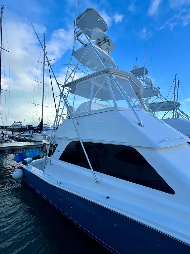 Slide: The Image of 1997 Viking 43 Convertible yacht docked at marina under blue sky. - 18
