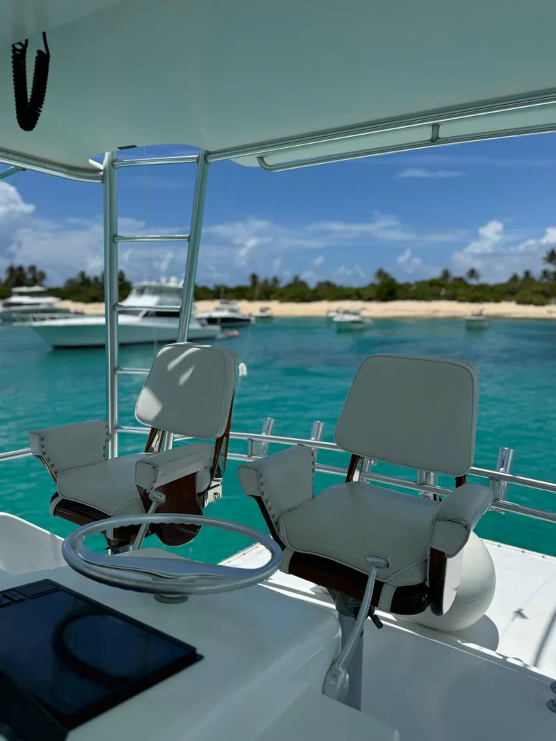 Slide: The Image of Two chairs on a 1997 Viking 43 Convertible yacht overlooking turquoise waters and a sandy beach. - 2