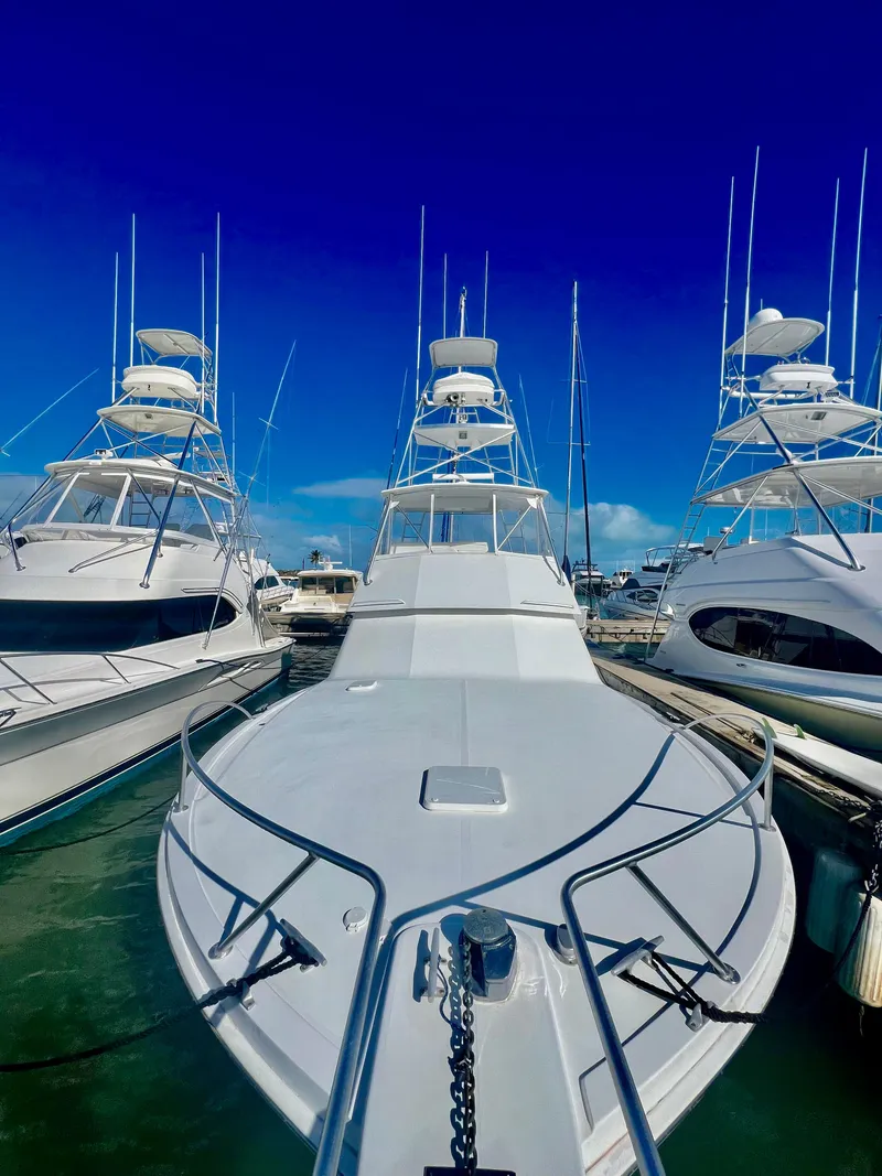 Slide: The Image of 1997 Viking 43 Convertible yacht docked at marina under clear blue sky. - 21