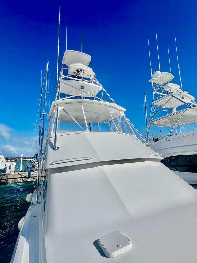 Slide: The Image of 1997 Viking 43 Convertible yacht docked at marina under clear blue sky. - 22