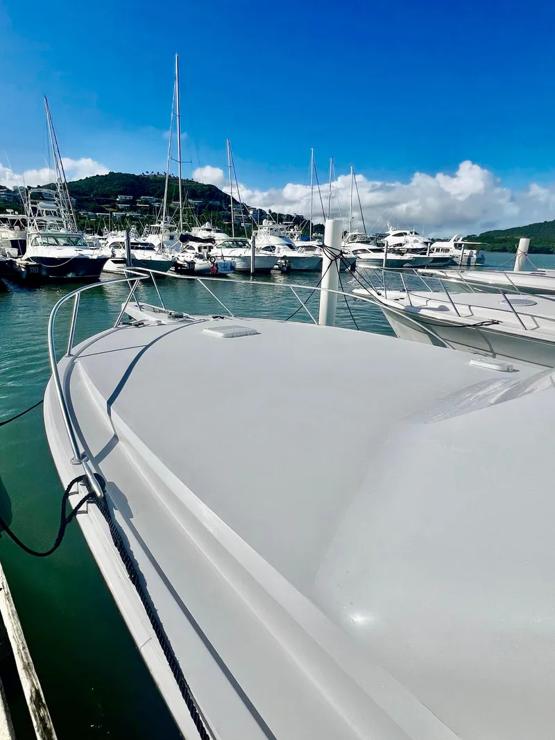 Slide: The Image of 1997 Viking 43 Convertible yacht docked in a marina with other boats. - 23