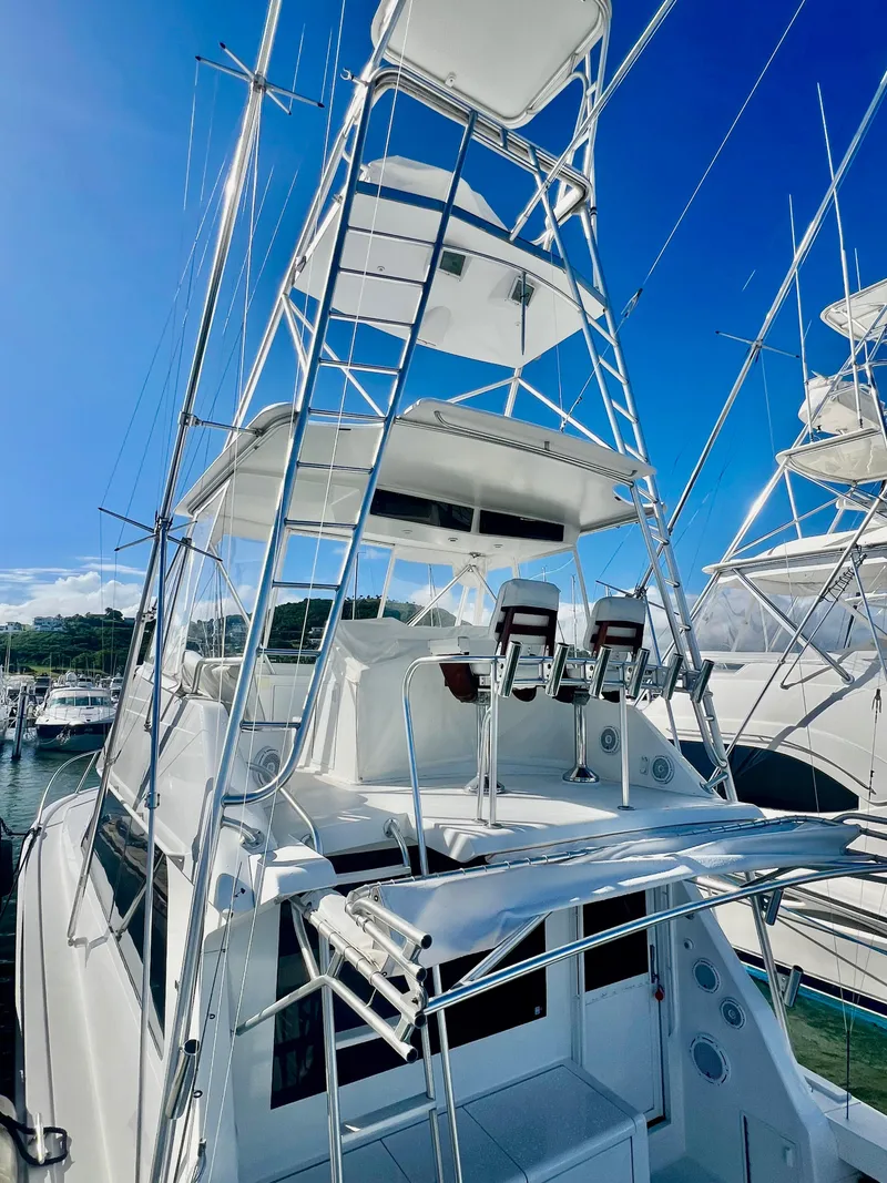 Slide: The Image of 1997 Viking 43 Convertible yacht with tower at marina, clear blue sky background. - 24