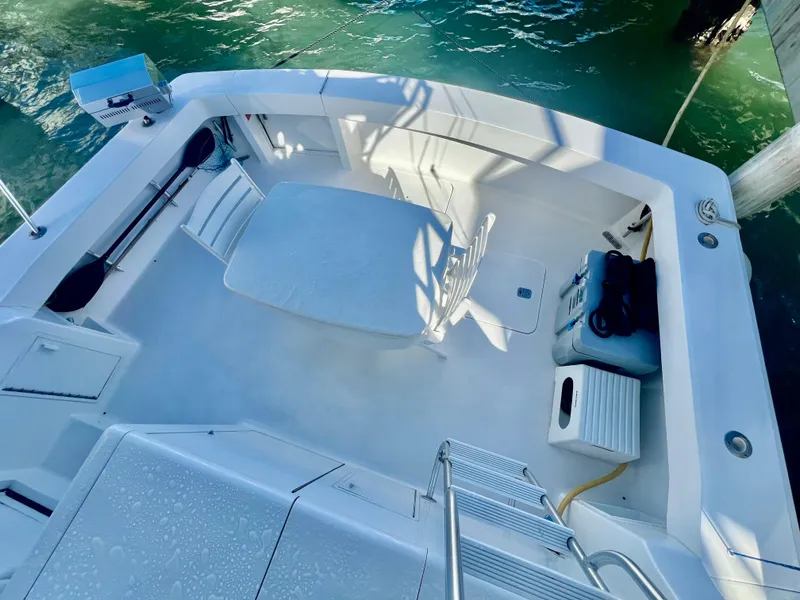 Slide: The Image of 1997 Viking 43 Convertible boat deck with seating and storage, docked by the water. - 26