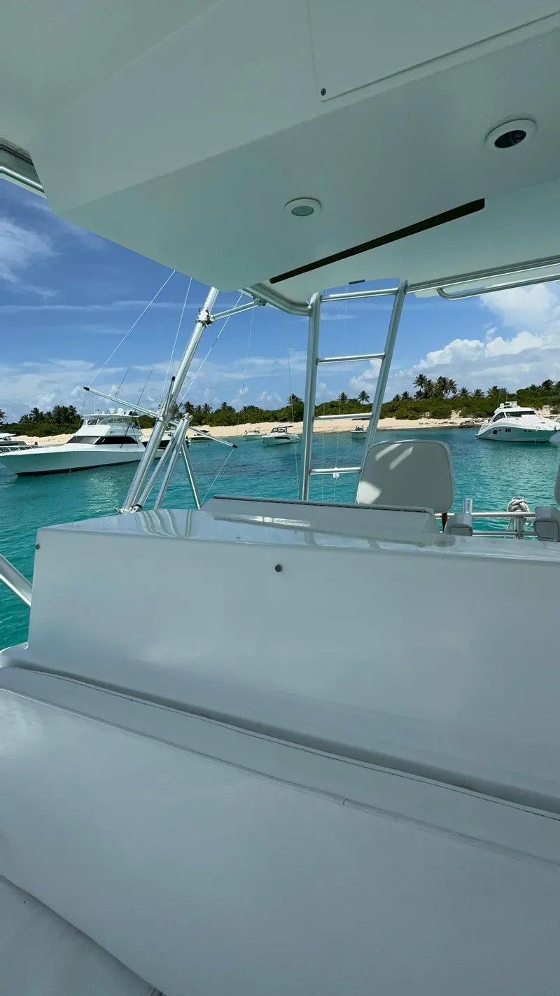 Slide: The Image of 1997 Viking 43 Convertible yacht on turquoise water, with other boats and a tropical shoreline. - 3