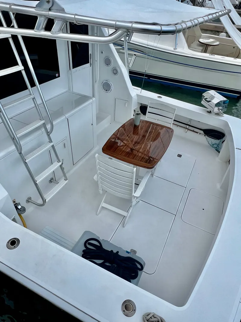 Slide: The Image of 1997 Viking 43 Convertible yacht deck with table, chairs, and ladder. - 43