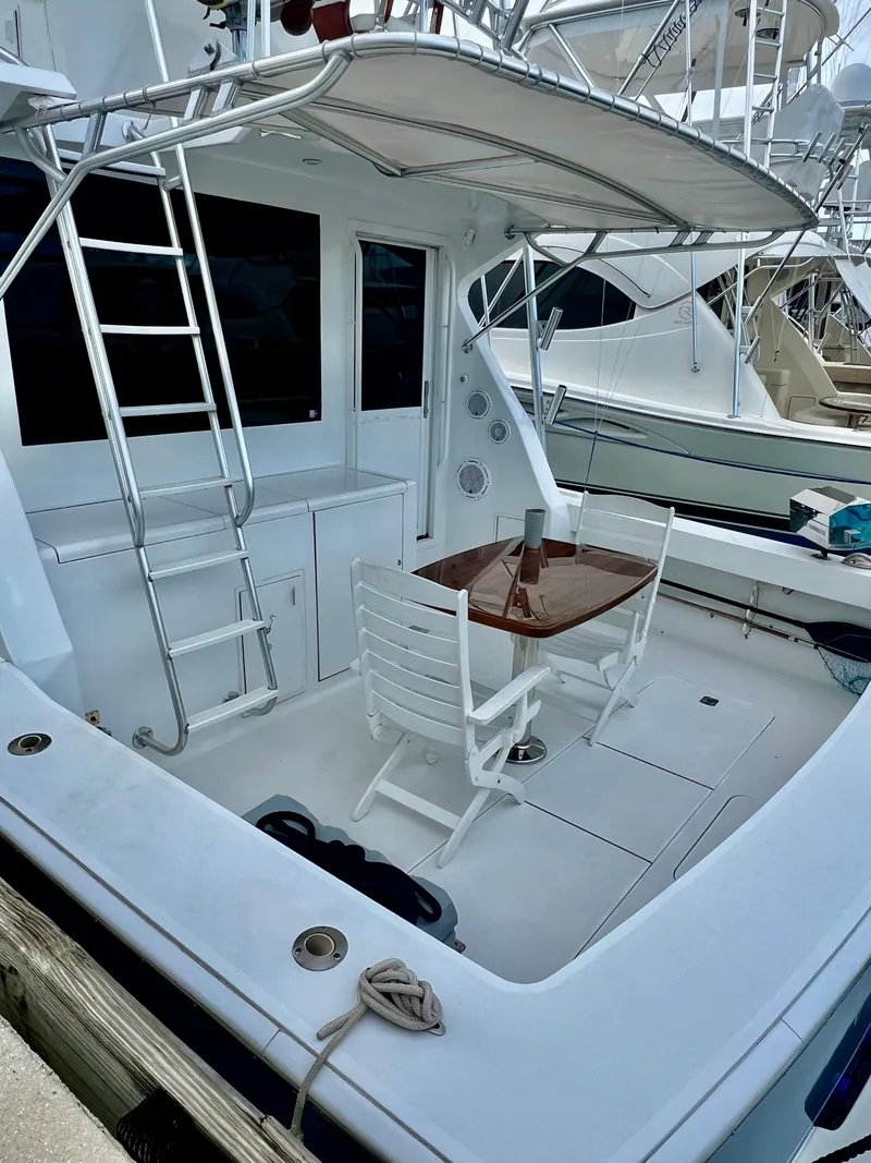 Slide: The Image of 1997 Viking 43 Convertible yacht with outdoor seating and ladder. - 44