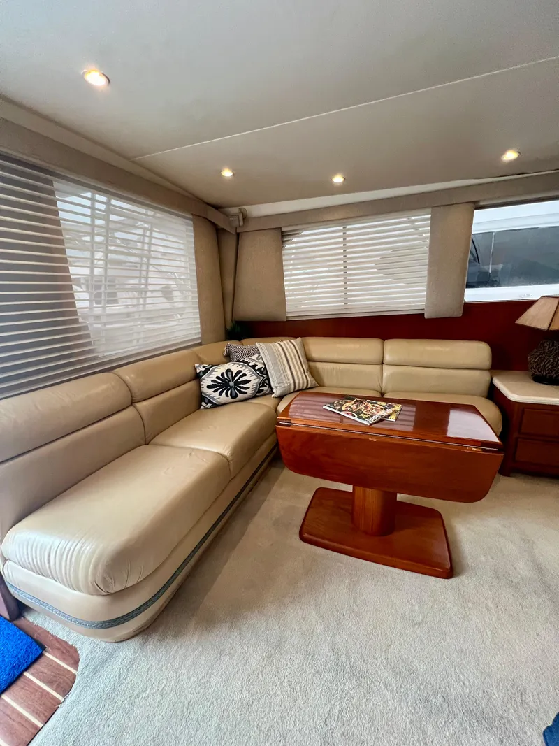 Slide: The Image of Interior of 1997 Viking 43 Convertible yacht with beige leather seating and wooden table. - 54