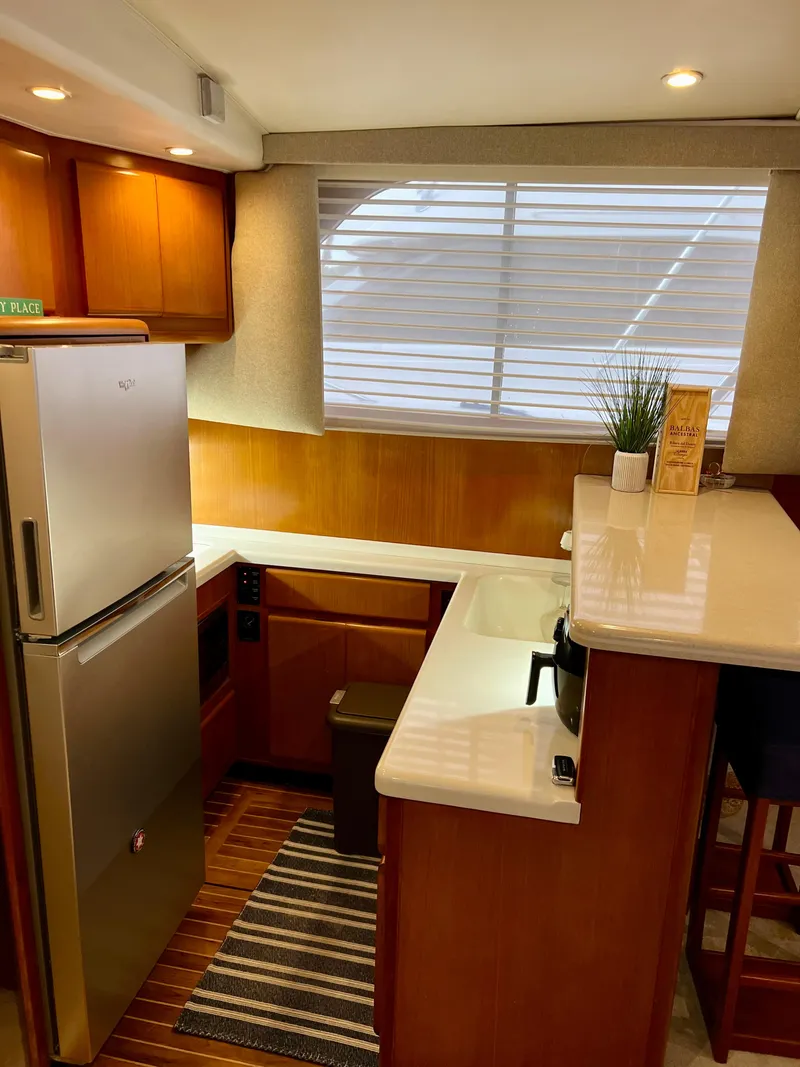 Slide: The Image of 1997 Viking 43 Convertible yacht kitchen with modern appliances and wooden cabinetry. - 56
