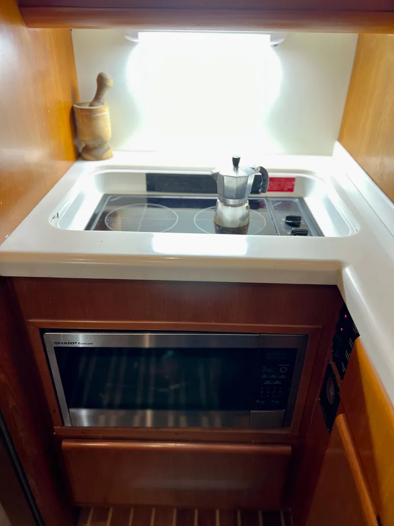 Slide: The Image of Compact kitchen area in a 1997 Viking 43 Convertible yacht with stovetop and microwave. - 58