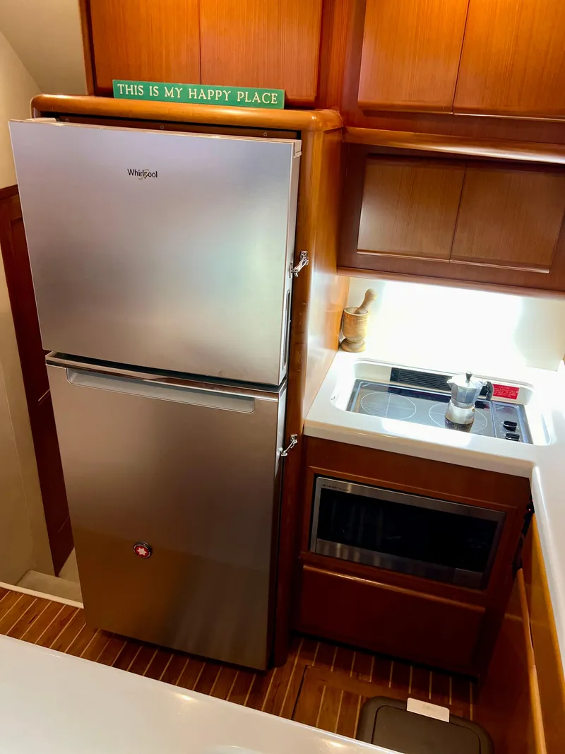 Slide: The Image of Compact kitchen in a 1997 Viking 43 Convertible boat with Whirlpool fridge and microwave. - 59