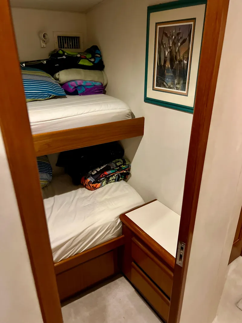 Slide: The Image of 1997 Viking 43 Convertible cabin with bunk beds and storage drawers. - 61