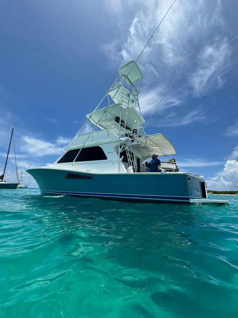 Slide: The Image of 1997 Viking 43 Convertible yacht on turquoise water under a clear blue sky. - 8
