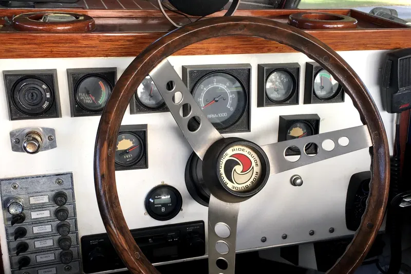 Slide: The Image of 1979 Skiff Craft Hard Top Cruiser dashboard with wooden steering wheel and gauges. - 12
