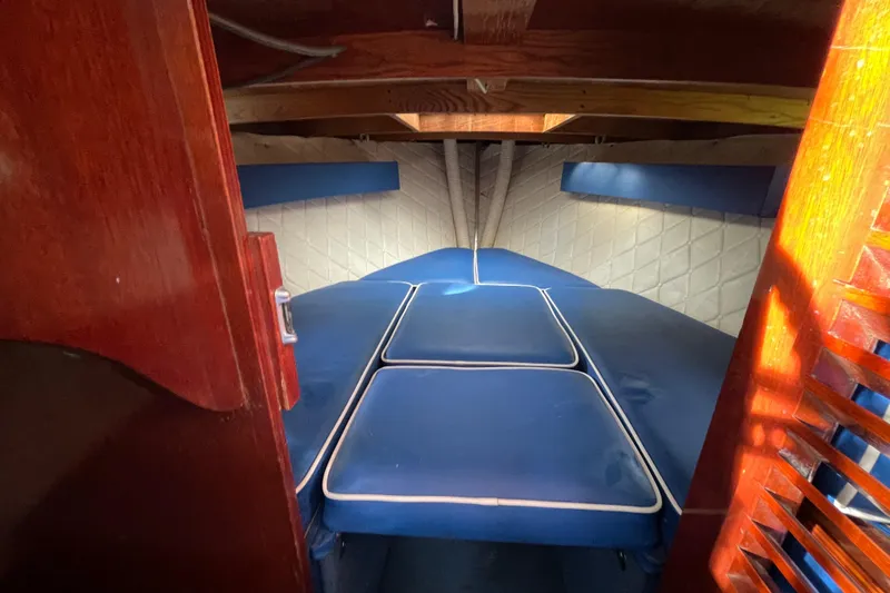 Slide: The Image of 1979 Skiff Craft Hard Top Cruiser cabin interior with blue cushions and wooden accents. - 16