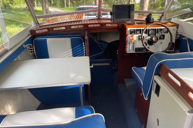 Slide: The Image of 1979 Skiff Craft Hard Top Cruiser interior with blue and white seating, steering wheel, and navigation equipment. - 18