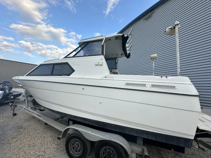 Slide: The Image of 1998 Bayliner 2452 Ciera Express boat on trailer, side view, clear sky background. - 13