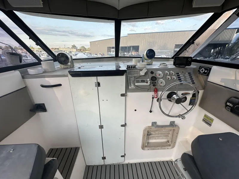 Slide: The Image of 1998 Bayliner 2452 Ciera Express boat cockpit with steering wheel and control panel. - 7