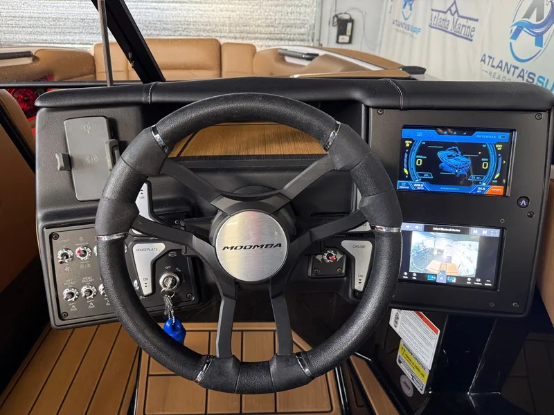 Slide: The Image of The image shows the cockpit of a 2024 Moomba Mojo with a modern steering wheel and digital displays. - 21