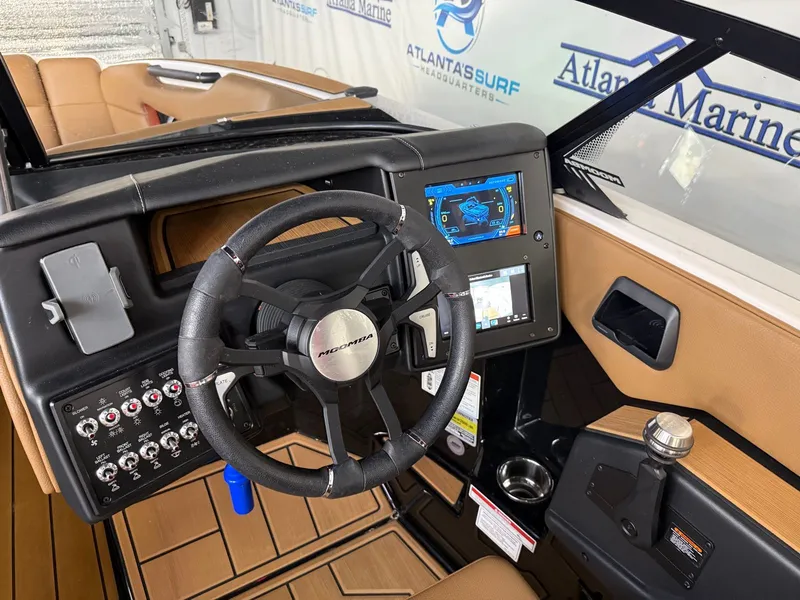 Slide: The Image of The image shows the cockpit of a 2024 Moomba Mojo with a modern steering wheel and touchscreen display. - 20