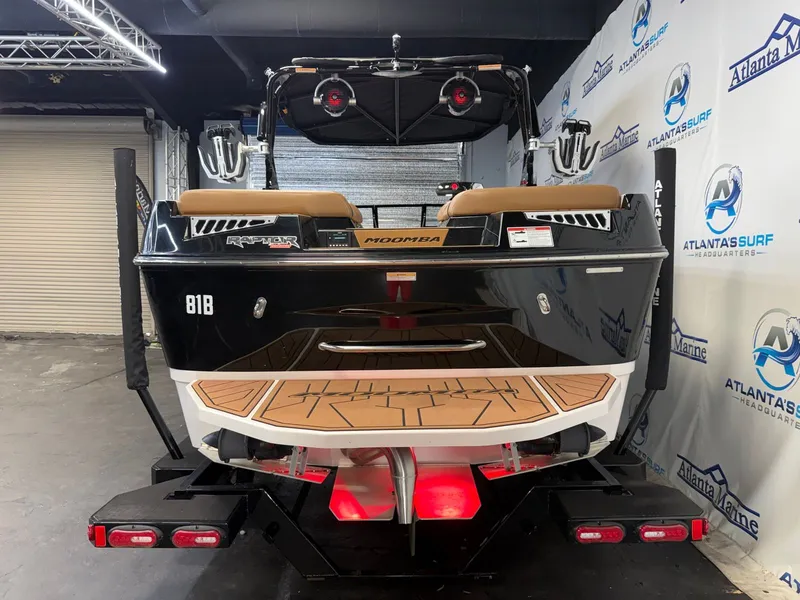 Slide: The Image of The image shows the rear of a 2024 Moomba Mojo boat in a showroom. - 7