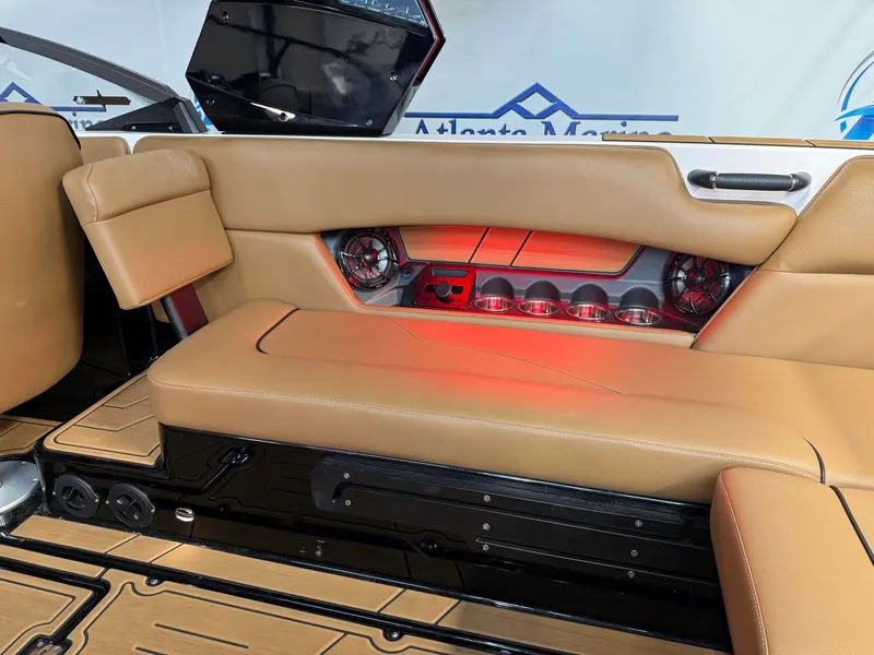 Slide: The Image of Interior of a 2024 Moomba Mojo with brown seating and red lighting. - 15