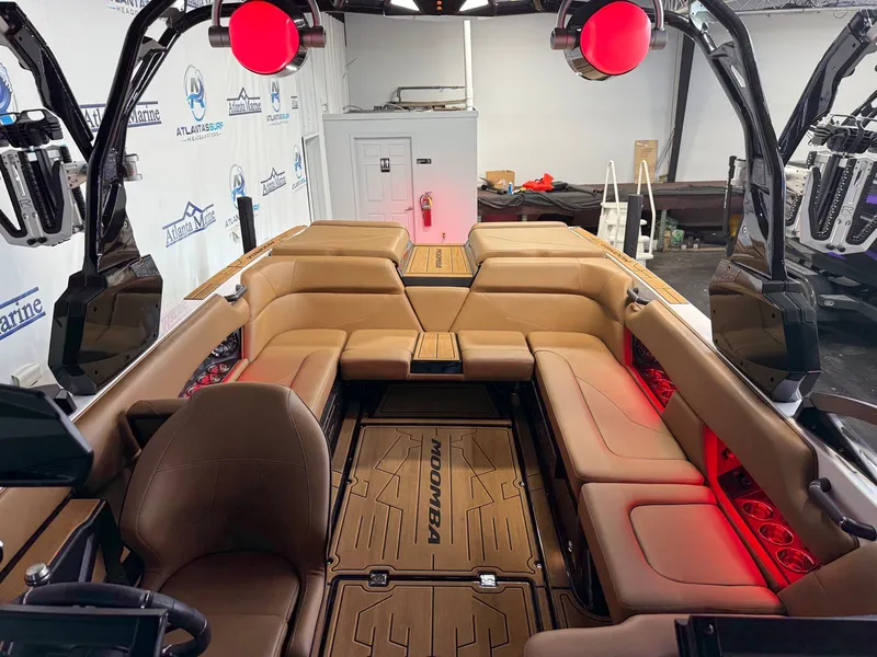 Slide: The Image of Interior of a 2024 Moomba Mojo with brown leather seating and red lighting. - 26