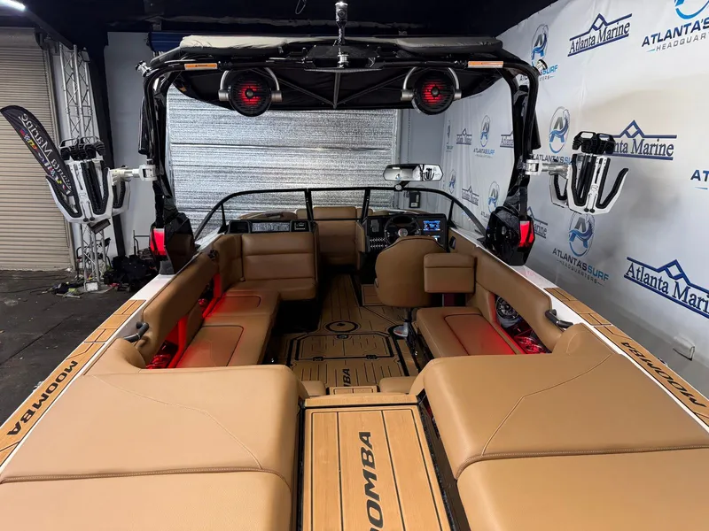Slide: The Image of Interior view of a 2024 Moomba Mojo with brown seating and a modern dashboard. - 10